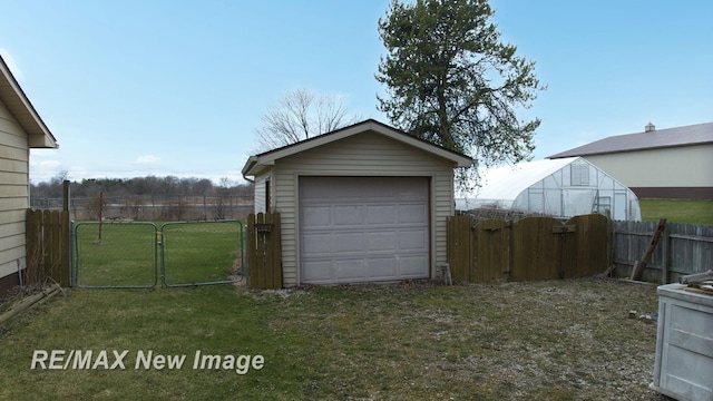 detached garage featuring fence and a gate