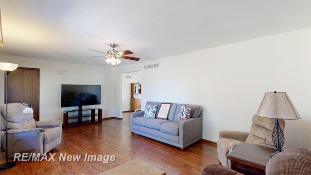 living area featuring visible vents, a ceiling fan, and wood finished floors