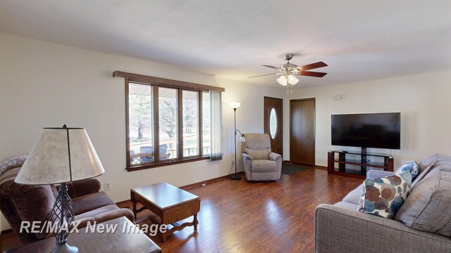 living room featuring baseboards, a ceiling fan, and wood finished floors