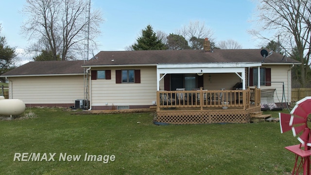 rear view of house with central AC, a wooden deck, and a lawn