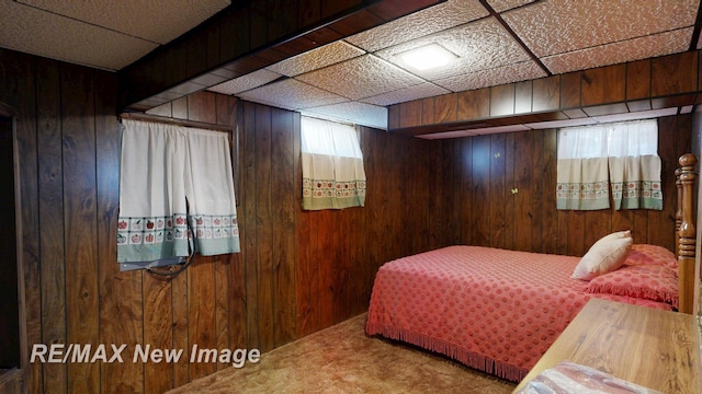 bedroom with wood walls and carpet
