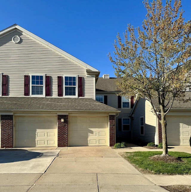 295 Victoria Dr, Dexter, MI 48130 - traditional home with brick siding, a garage, and driveway