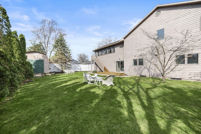 back of house featuring fence, a lawn, and stairway