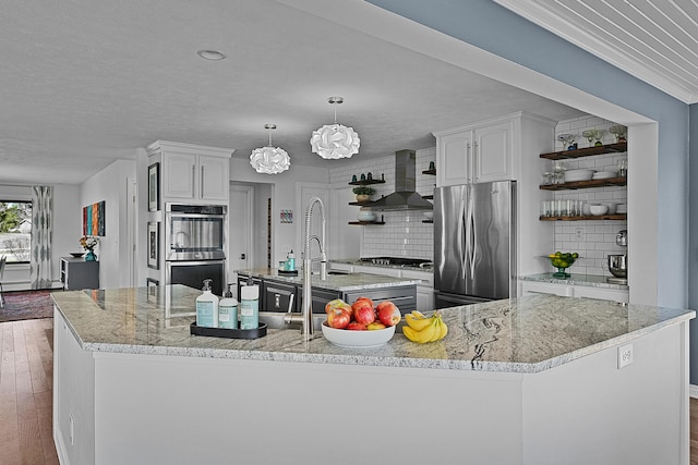 2370 Holtman Dr NE, Grand Rapids, MI 49525 - kitchen featuring open shelves, wall chimney range hood, stainless steel appliances, a kitchen island with sink, and hardwood / wood-style floors