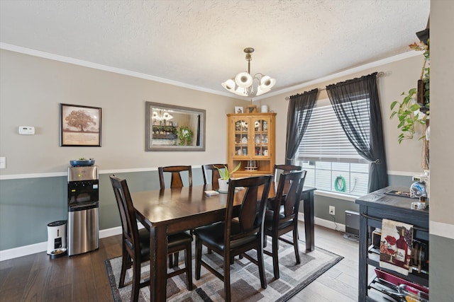 dining room with a chandelier, hardwood / wood-style flooring, a textured ceiling, and crown molding
