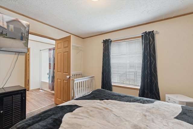 bedroom with a textured ceiling and wood finished floors