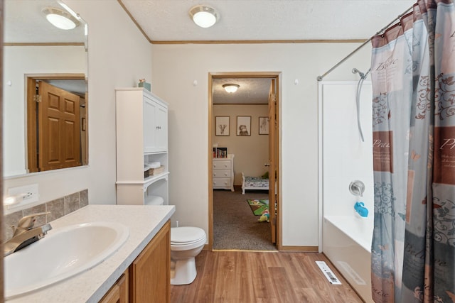 bathroom with vanity, a textured ceiling, ornamental molding, and wood finished floors