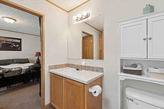 ensuite bathroom featuring vanity, ensuite bath, a textured ceiling, crown molding, and toilet