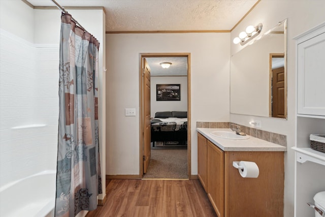 full bath featuring shower / bath combination with curtain, ornamental molding, a textured ceiling, vanity, and wood finished floors