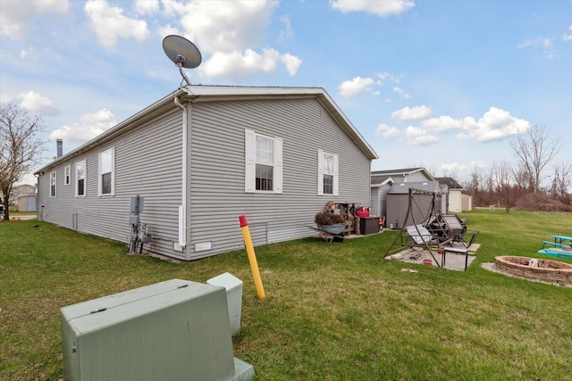 view of home's exterior featuring a yard and an outdoor fire pit