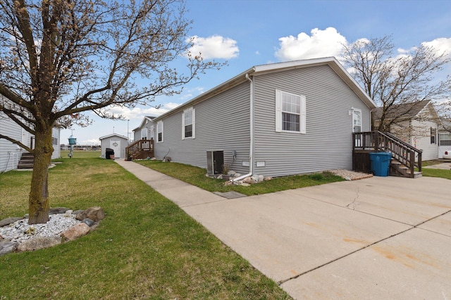 view of side of home featuring a lawn and central air condition unit