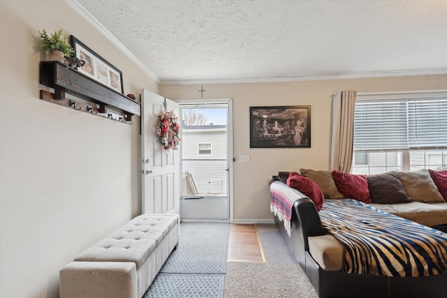 bedroom featuring baseboards, a textured ceiling, crown molding, and wood finished floors