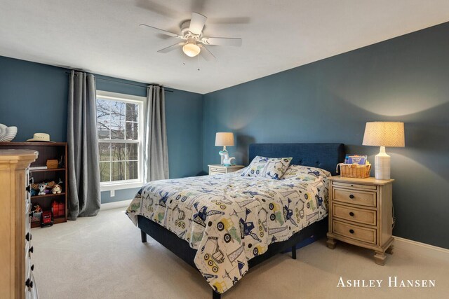 carpeted bedroom with ceiling fan and baseboards