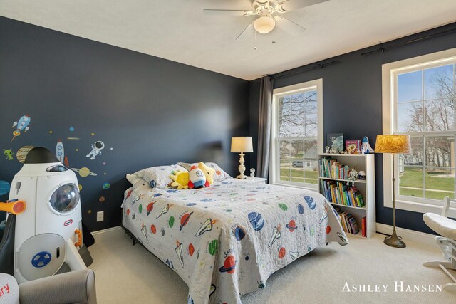 bedroom with baseboards, multiple windows, and carpet flooring