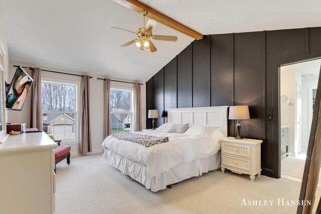 bedroom featuring a decorative wall, a ceiling fan, light colored carpet, and lofted ceiling with beams