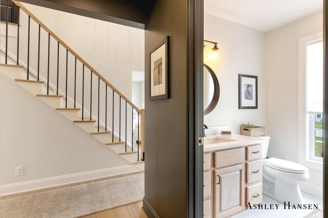 bathroom with vanity, baseboards, toilet, and wood finished floors