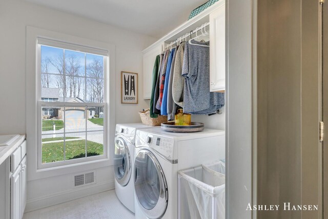 washroom with separate washer and dryer, visible vents, cabinet space, and a wealth of natural light