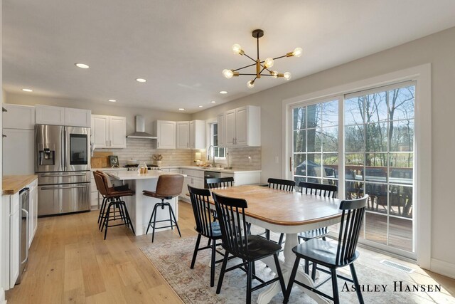 dining area featuring light wood-style floors, a notable chandelier, visible vents, and recessed lighting