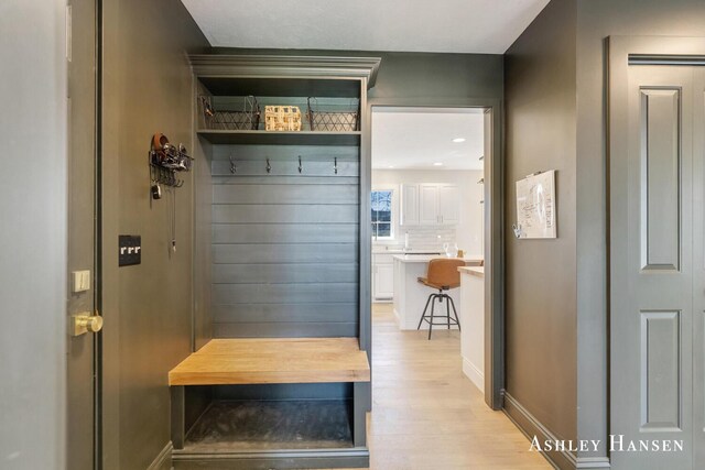 mudroom featuring baseboards and light wood-style floors