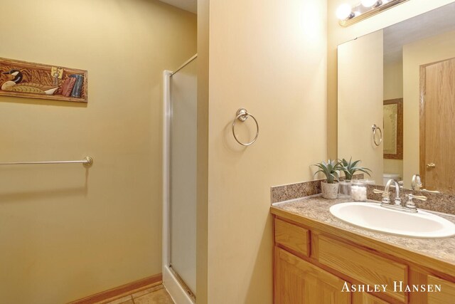 bathroom with a stall shower, vanity, and tile patterned floors