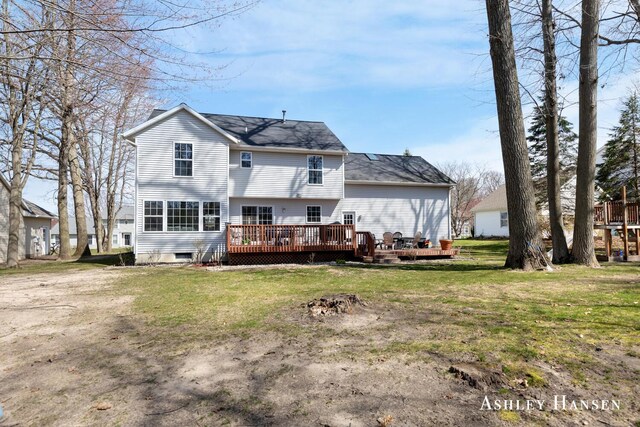 rear view of property featuring a deck and a lawn