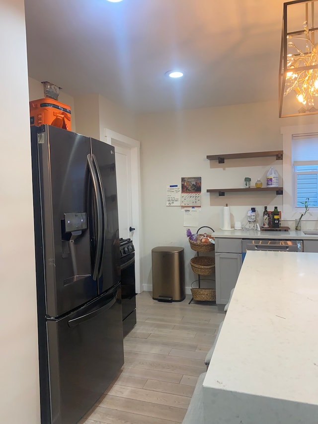 4519 Washington St, Wayne, MI 48184 - kitchen with a sink, light wood-type flooring, an inviting chandelier, light countertops, and black appliances