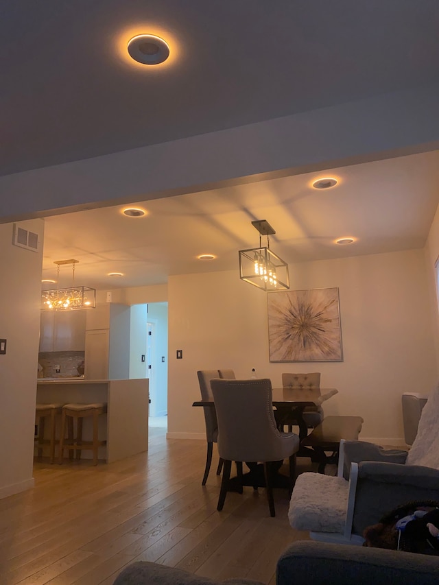 4519 Washington St, Wayne, MI 48184 - dining space with light wood-style flooring, visible vents, baseboards, and a notable chandelier