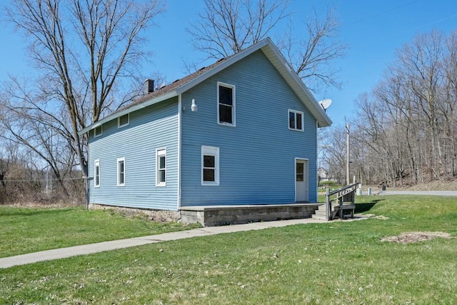 view of home's exterior featuring a lawn and a chimney