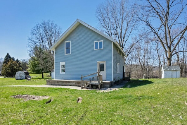 rear view of property featuring a shed, a yard, and an outdoor structure