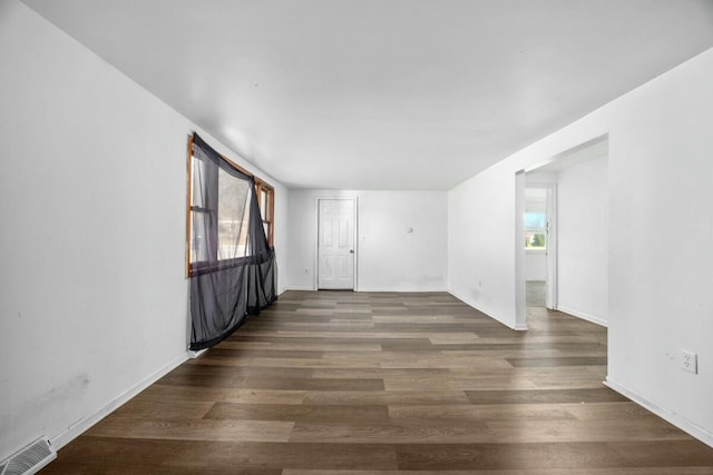 spare room featuring wood finished floors, baseboards, and visible vents