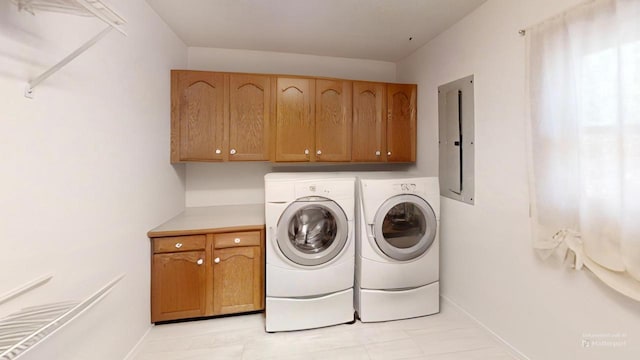 laundry room featuring cabinet space, baseboards, washer and dryer, and electric panel