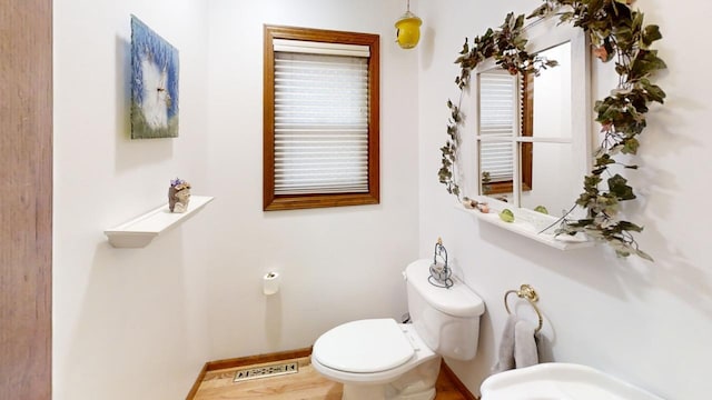 bathroom with toilet, baseboards, and visible vents