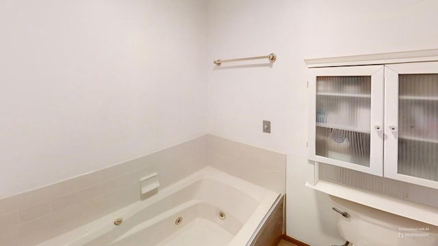 full bathroom with toilet and a tub with jets