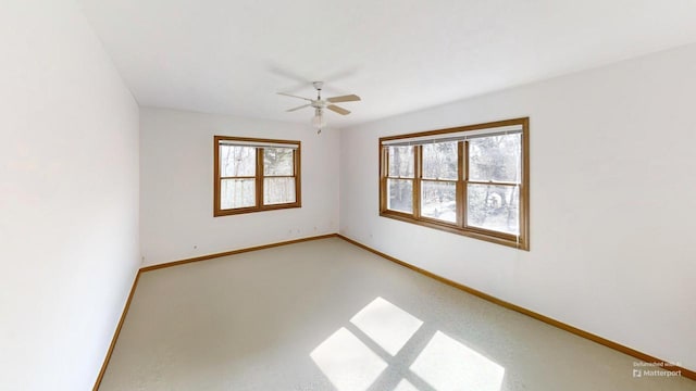 spare room with baseboards and a ceiling fan