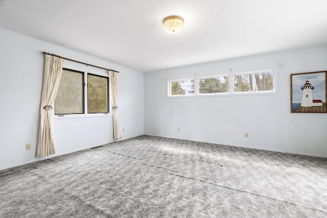 empty room featuring baseboards and carpet floors