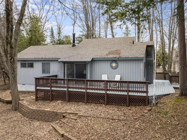 rear view of house featuring a deck, crawl space, and a shingled roof