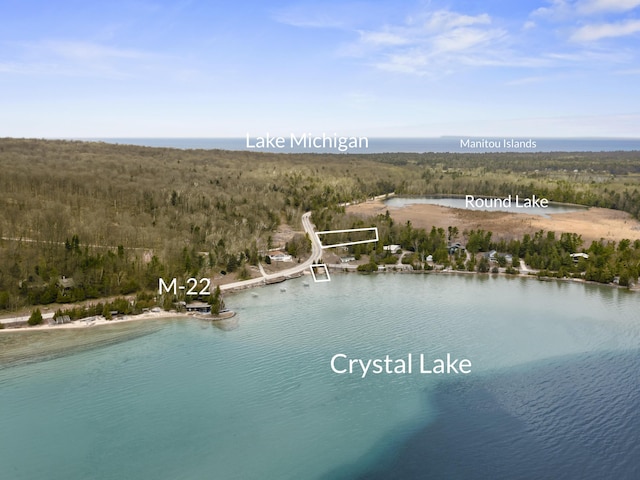 drone / aerial view with a forest view and a water view