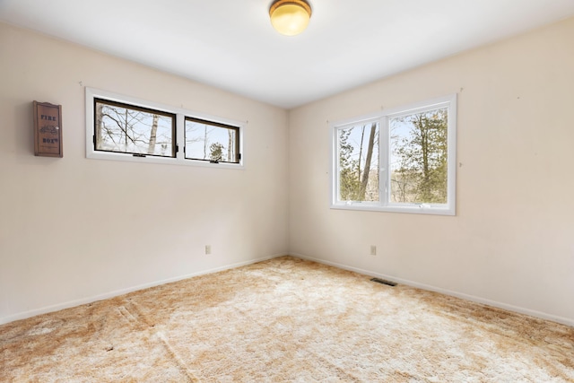 spare room with baseboards, carpet, and visible vents