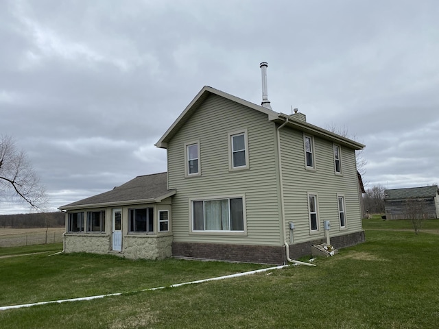 rear view of property featuring a yard and a chimney