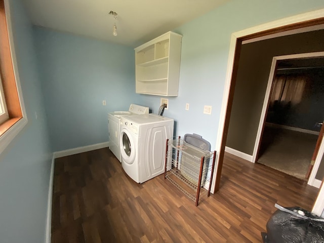 washroom featuring dark wood-style floors, washer and clothes dryer, baseboards, and laundry area