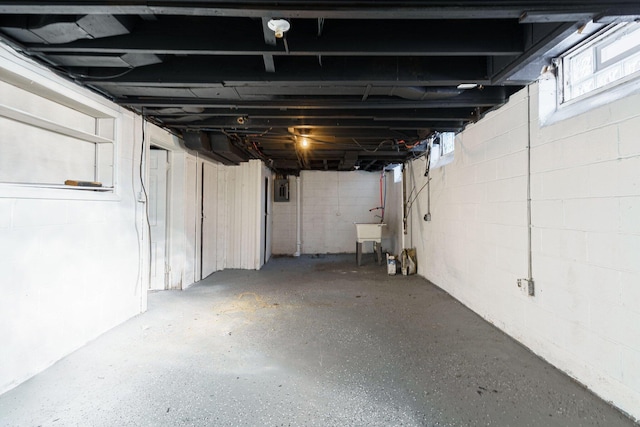 below grade area featuring electric panel and concrete block wall