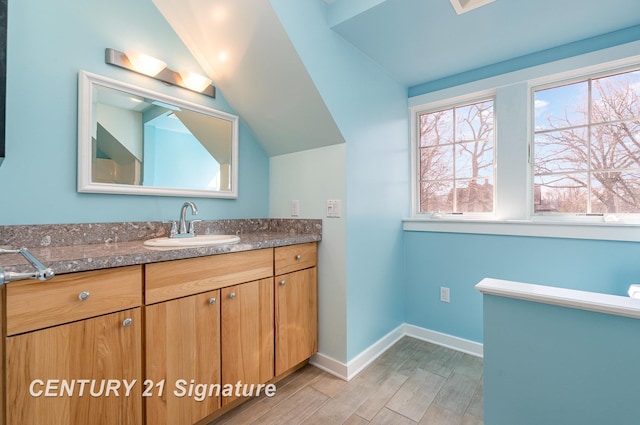 105 Parkwood Ct, Bay City, MI 48706 - bathroom featuring wood finished floors, vanity, baseboards, and lofted ceiling