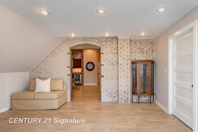 105 Parkwood Ct, Bay City, MI 48706 - living area featuring recessed lighting, wood finished floors, vaulted ceiling, and brick wall