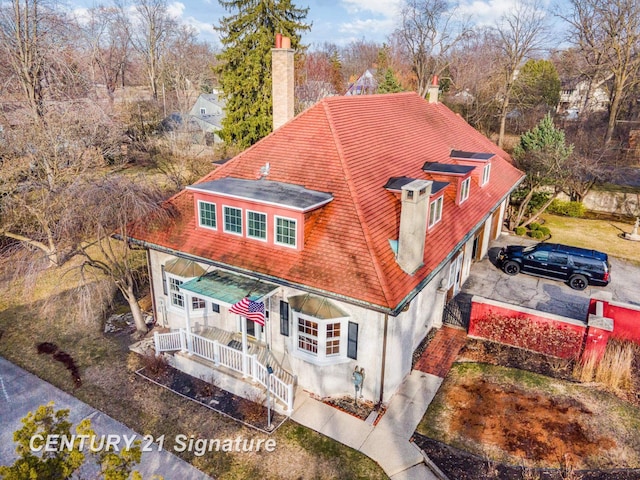 105 Parkwood Ct, Bay City, MI 48706 - back of property with a shingled roof, covered porch, stucco siding, and a chimney