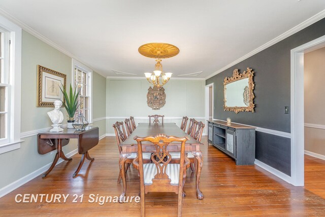 105 Parkwood Ct, Bay City, MI 48706 - dining space with baseboards, an inviting chandelier, crown molding, and wood finished floors