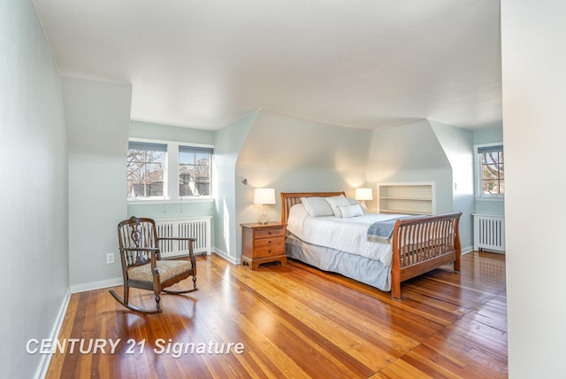 105 Parkwood Ct, Bay City, MI 48706 - bedroom with radiator heating unit, hardwood / wood-style flooring, and multiple windows