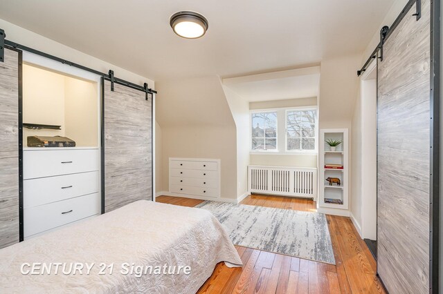 105 Parkwood Ct, Bay City, MI 48706 - bedroom featuring hardwood / wood-style floors, radiator heating unit, baseboards, and a barn door