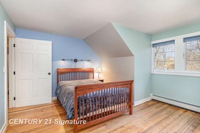 105 Parkwood Ct, Bay City, MI 48706 - bedroom with a baseboard radiator, vaulted ceiling, hardwood / wood-style flooring, and baseboards
