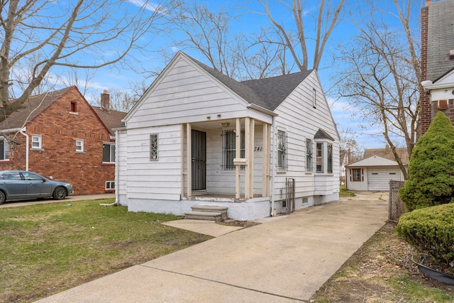 7416 Heyden St, Detroit, MI 48228 - bungalow-style home with a detached garage, an outbuilding, a front lawn, driveway, and roof with shingles