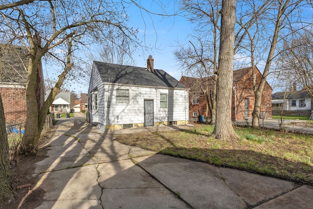 7416 Heyden St, Detroit, MI 48228 - rear view of house featuring concrete driveway, fence, and a chimney
